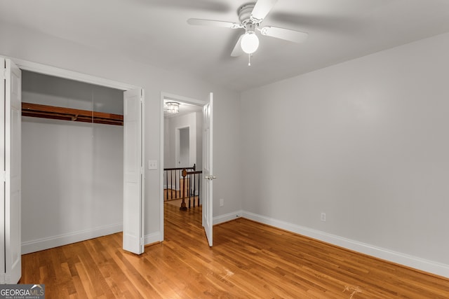 unfurnished bedroom with ceiling fan, a closet, and light wood-type flooring