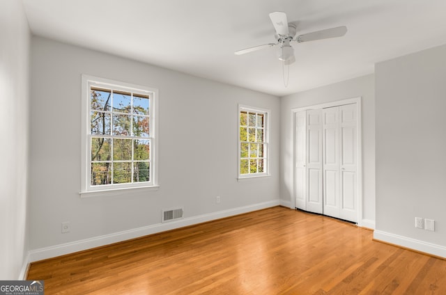 unfurnished bedroom featuring light wood-type flooring, a closet, and ceiling fan