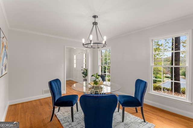 dining area featuring a chandelier, wood-type flooring, and ornamental molding