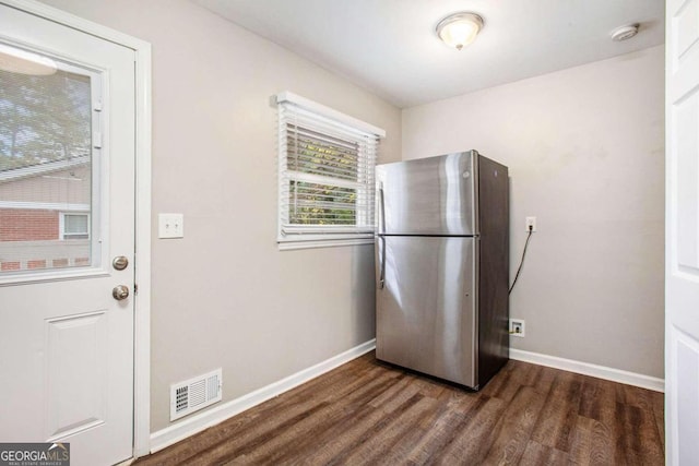 kitchen with dark hardwood / wood-style flooring and stainless steel refrigerator