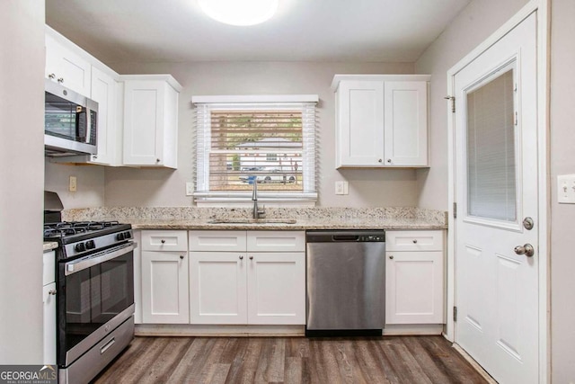 kitchen featuring stainless steel appliances, white cabinetry, sink, and dark wood-type flooring