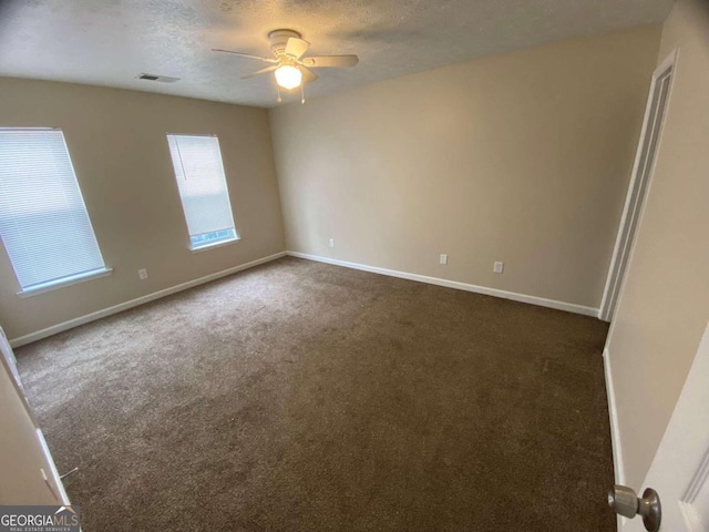 carpeted empty room featuring ceiling fan and a textured ceiling