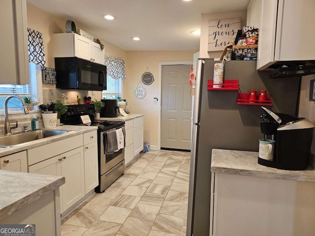 kitchen with sink, decorative backsplash, stainless steel appliances, and white cabinets