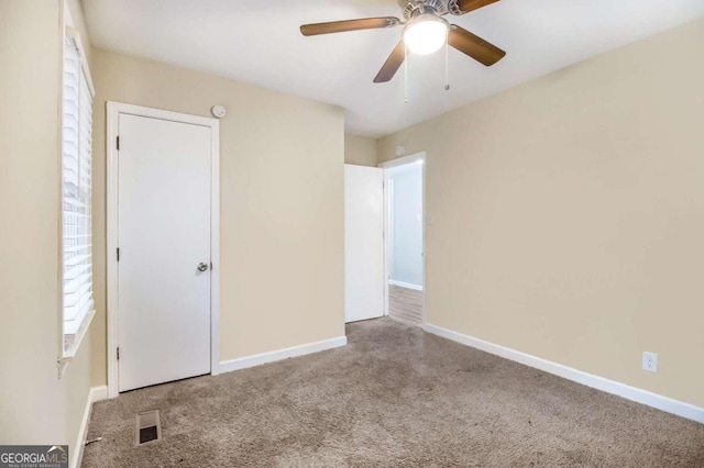 unfurnished bedroom with ceiling fan and carpet floors