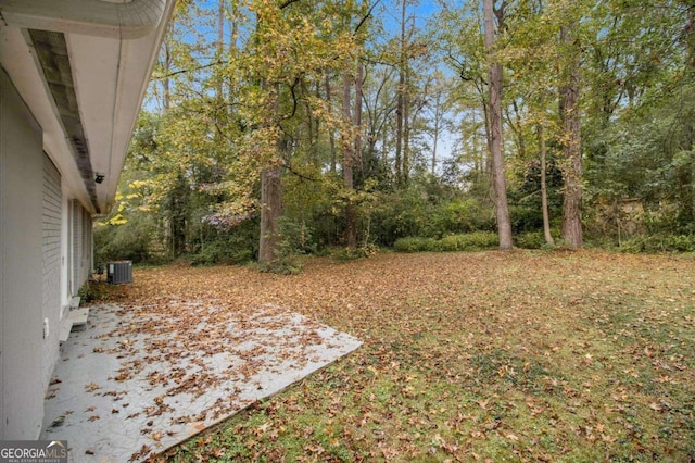 view of yard with central air condition unit and a patio area