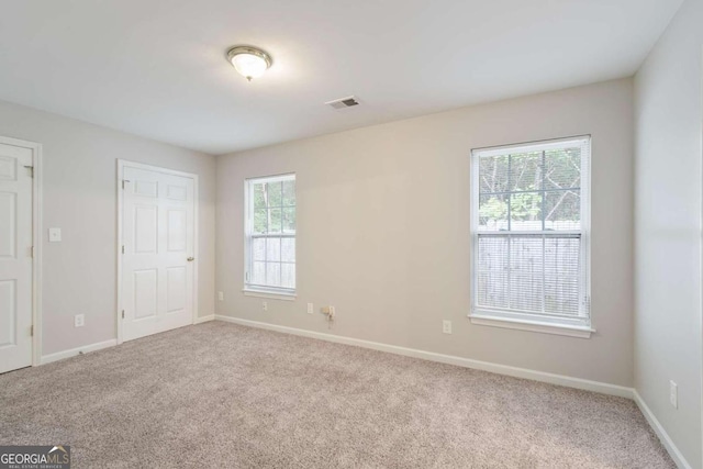 unfurnished room with carpet floors and plenty of natural light