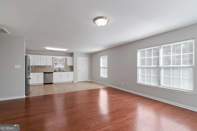 unfurnished living room featuring light hardwood / wood-style flooring and sink