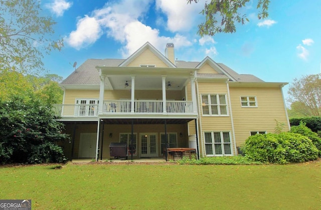 rear view of property featuring a lawn, a hot tub, and a patio area