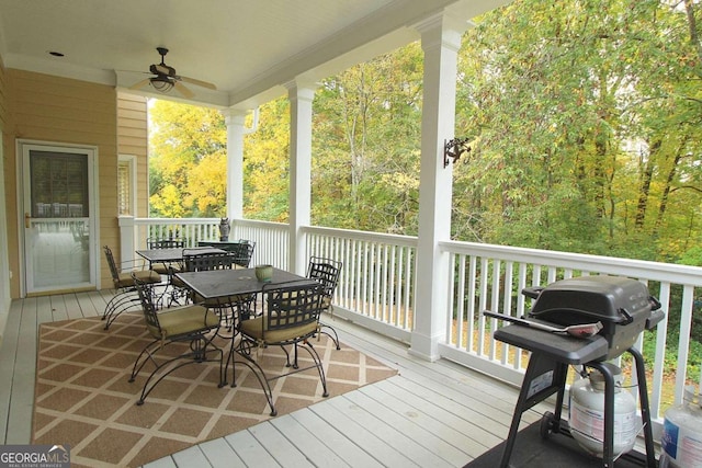 wooden deck with area for grilling and ceiling fan