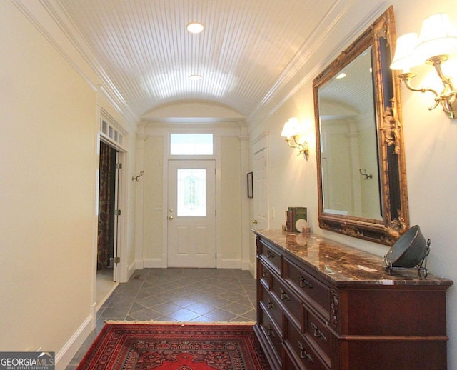 entryway with ornamental molding and light tile patterned floors