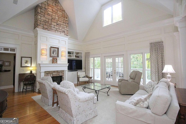 living room with high vaulted ceiling, a fireplace, wood-type flooring, and plenty of natural light