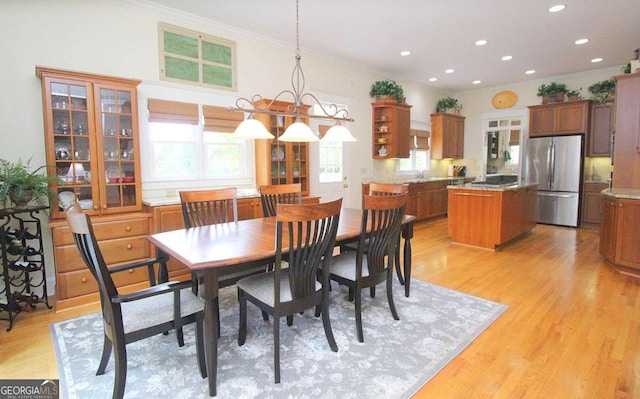 dining space featuring light hardwood / wood-style floors and crown molding