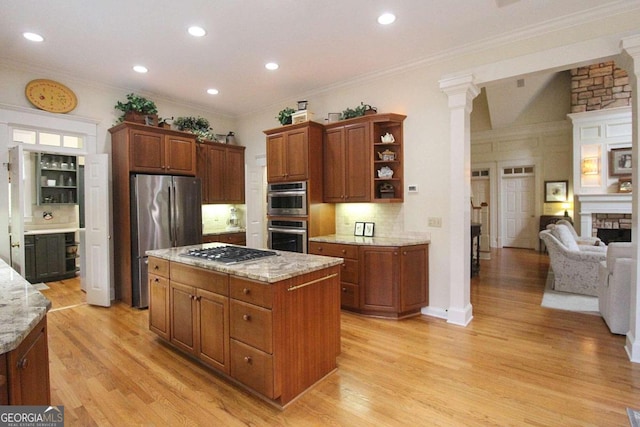 kitchen with tasteful backsplash, crown molding, a kitchen island, light wood-type flooring, and appliances with stainless steel finishes