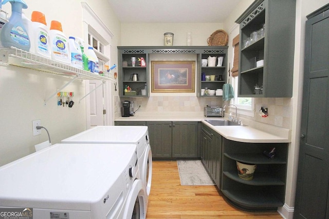 kitchen featuring separate washer and dryer, sink, light hardwood / wood-style flooring, and tasteful backsplash