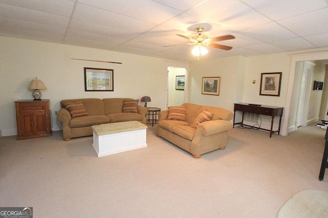 carpeted living room featuring ceiling fan and a drop ceiling