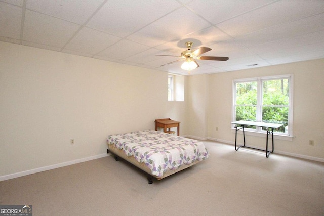 bedroom with a drop ceiling, carpet flooring, and ceiling fan