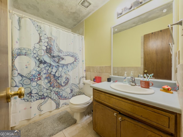 bathroom featuring a shower with curtain, vanity, tile walls, tile patterned flooring, and toilet