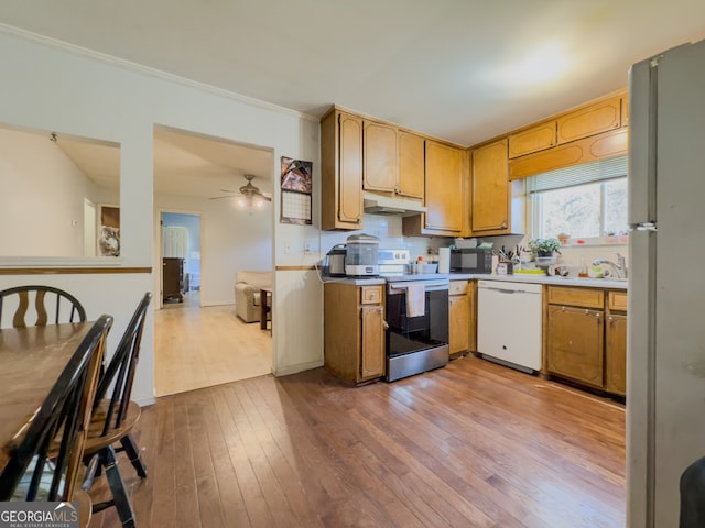 kitchen with white appliances, crown molding, light hardwood / wood-style flooring, ceiling fan, and tasteful backsplash