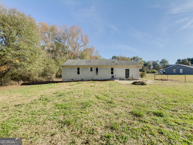 rear view of property featuring a patio area and a lawn