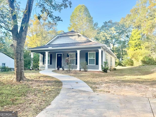 bungalow featuring covered porch and a front lawn