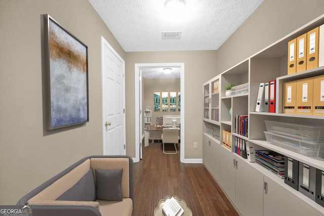 hall with dark wood-type flooring and a textured ceiling