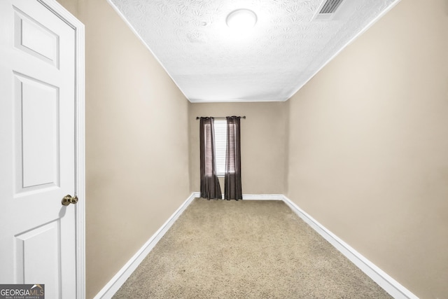 carpeted empty room featuring a textured ceiling