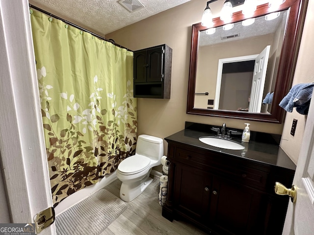 bathroom with vanity, a textured ceiling, and toilet