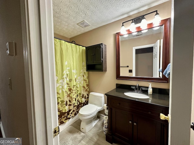 bathroom with vanity, a textured ceiling, toilet, and a shower with shower curtain