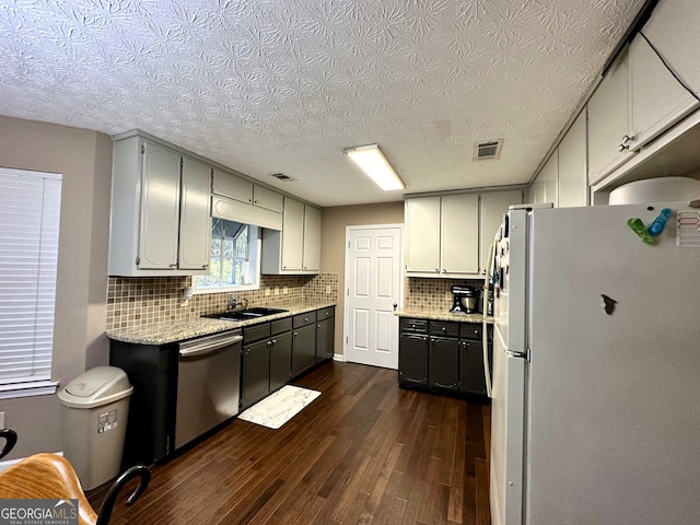 kitchen featuring sink, tasteful backsplash, dark hardwood / wood-style floors, white fridge, and dishwasher