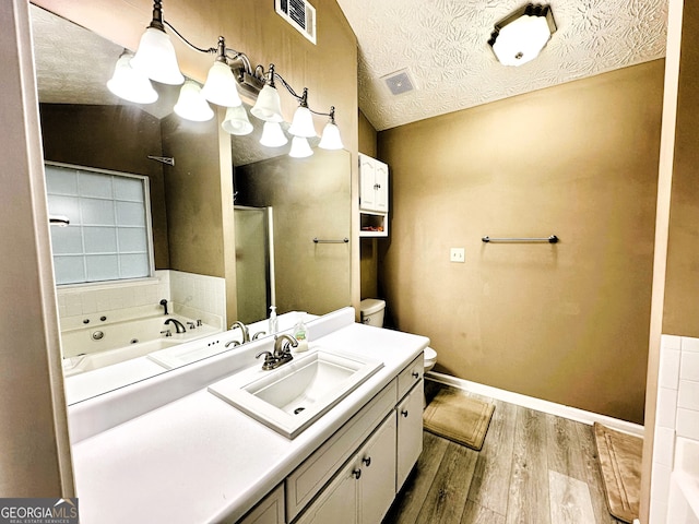 full bathroom featuring vanity, a textured ceiling, hardwood / wood-style flooring, and vaulted ceiling