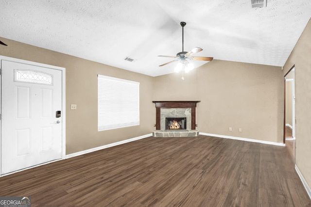 unfurnished living room with lofted ceiling, dark hardwood / wood-style floors, a textured ceiling, and a fireplace