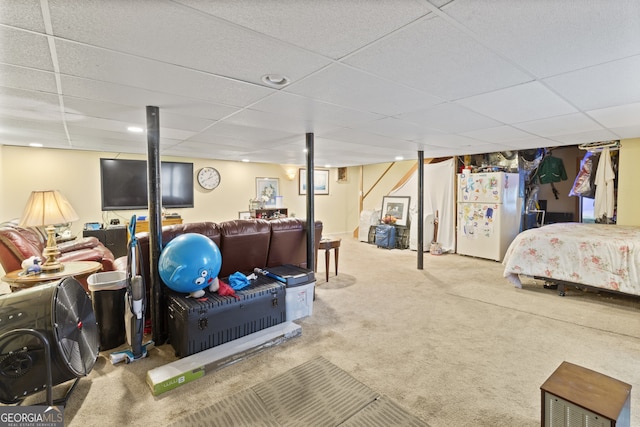 carpeted bedroom featuring white fridge and a drop ceiling