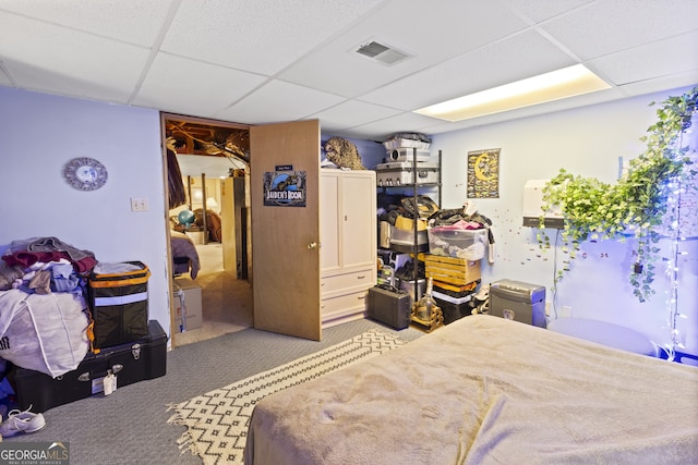 bedroom featuring a paneled ceiling and carpet floors