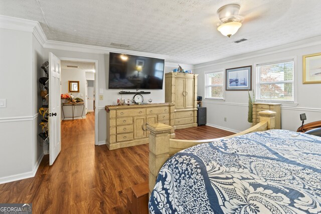 bedroom featuring a textured ceiling, dark hardwood / wood-style flooring, ceiling fan, and crown molding