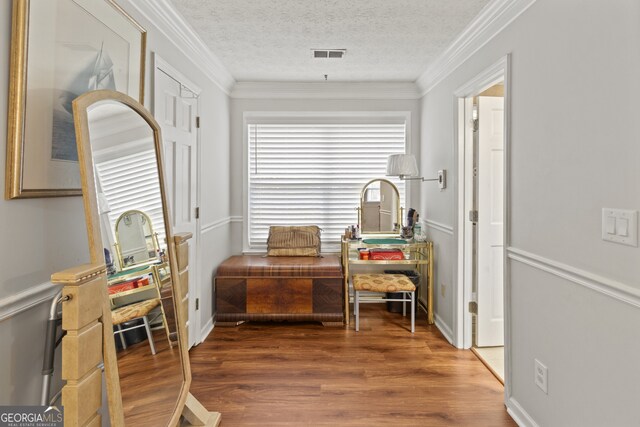 sitting room featuring dark wood-type flooring, a textured ceiling, and ornamental molding