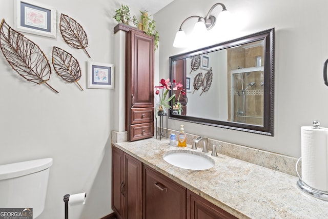 bathroom with walk in shower, vanity, and toilet