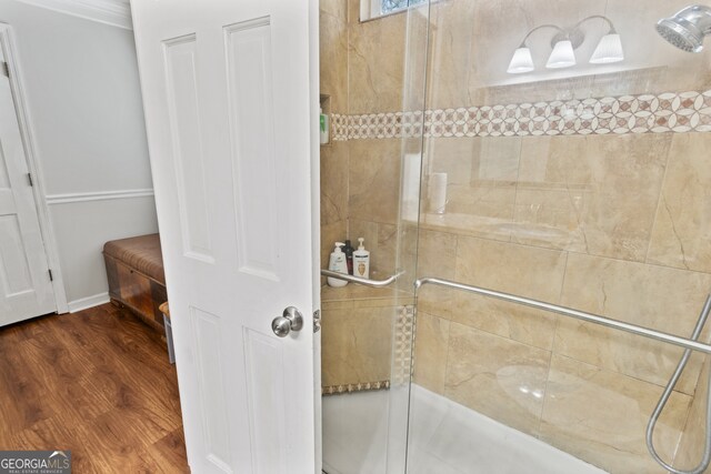 bathroom with hardwood / wood-style flooring and tiled shower