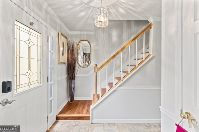 entrance foyer with light hardwood / wood-style flooring, a notable chandelier, and crown molding