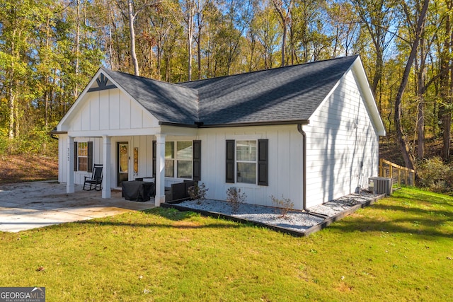 view of front facade with central AC unit, a front lawn, and a patio