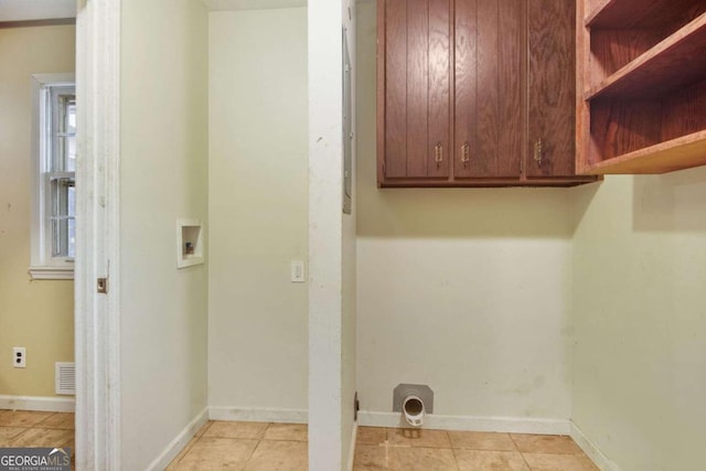 laundry room featuring electric dryer hookup, hookup for a washing machine, cabinets, and light tile patterned flooring