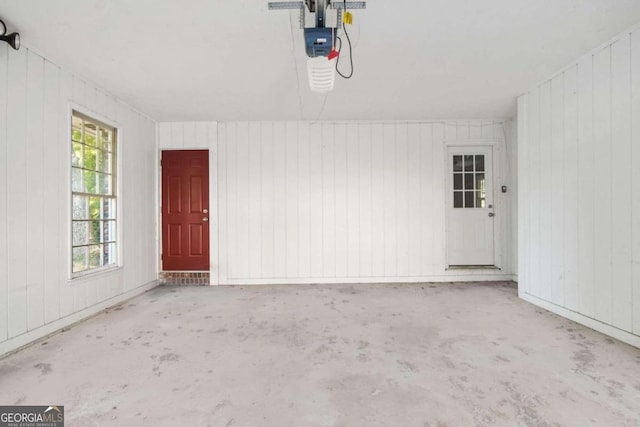 garage with a garage door opener and wooden walls