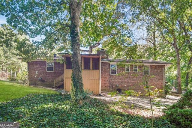 exterior space with central air condition unit and a yard