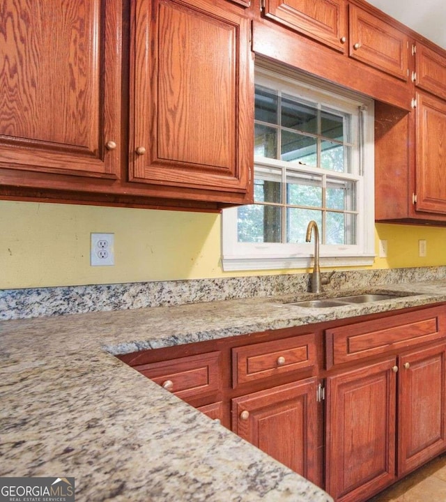 kitchen featuring sink and light stone counters