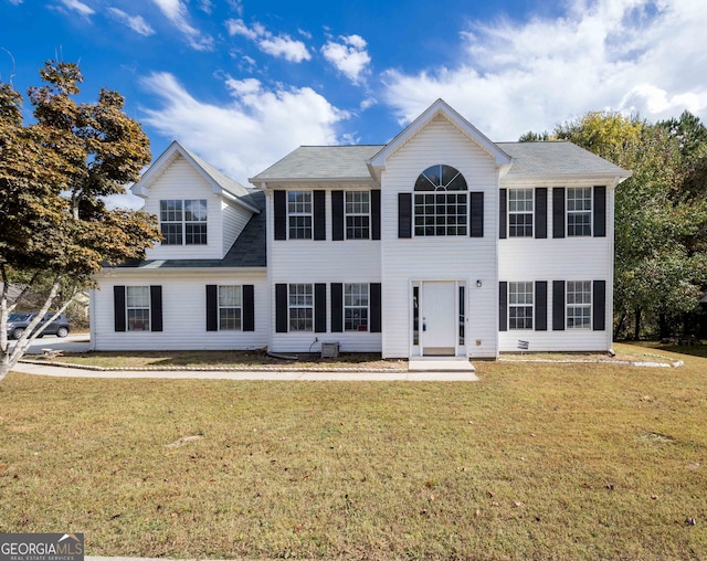 colonial house featuring a front lawn