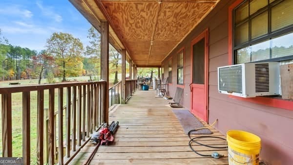 wooden deck with a porch and cooling unit