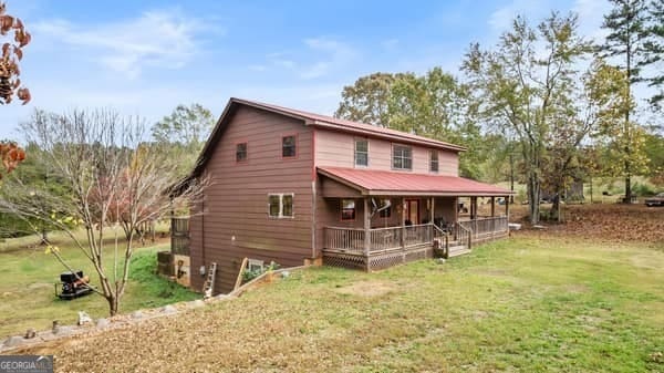 rear view of property with a yard and a porch