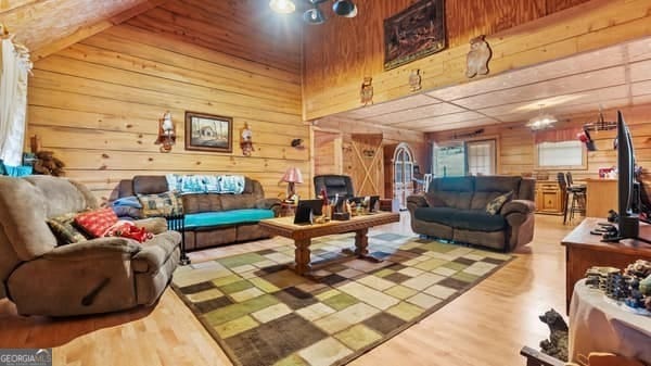 living room with hardwood / wood-style flooring and wood walls