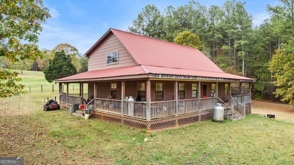 farmhouse-style home featuring covered porch and a front yard