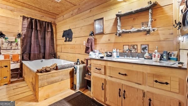 misc room featuring wood walls, light hardwood / wood-style floors, sink, and wooden ceiling