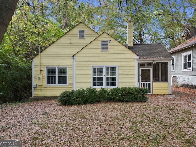 back of property with a sunroom